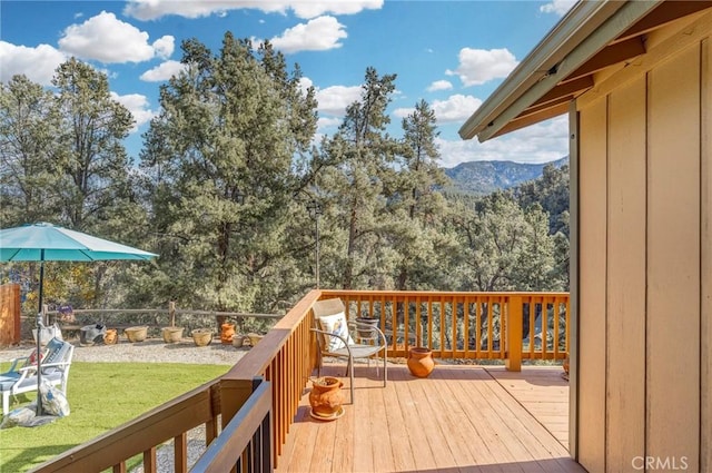 wooden deck with a lawn and a mountain view