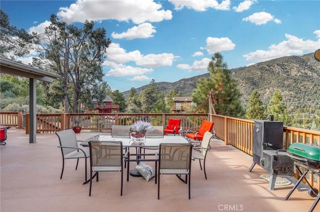 view of patio / terrace with a mountain view, outdoor dining area, and grilling area