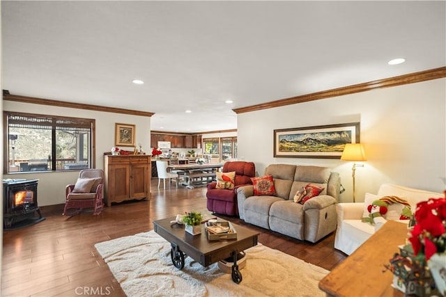 living room with recessed lighting, ornamental molding, dark wood-type flooring, and a wood stove