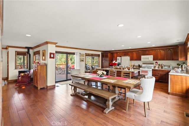 dining space with hardwood / wood-style floors, ornamental molding, and sink