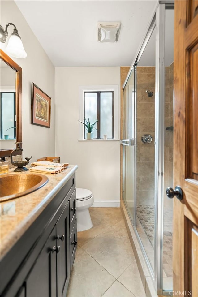 bathroom with tile patterned floors, vanity, toilet, and walk in shower