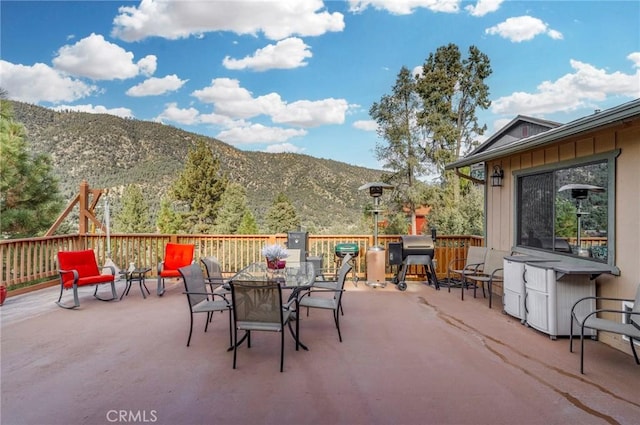view of patio / terrace with outdoor dining area, grilling area, and a mountain view
