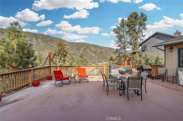 view of patio with a mountain view and outdoor dining space