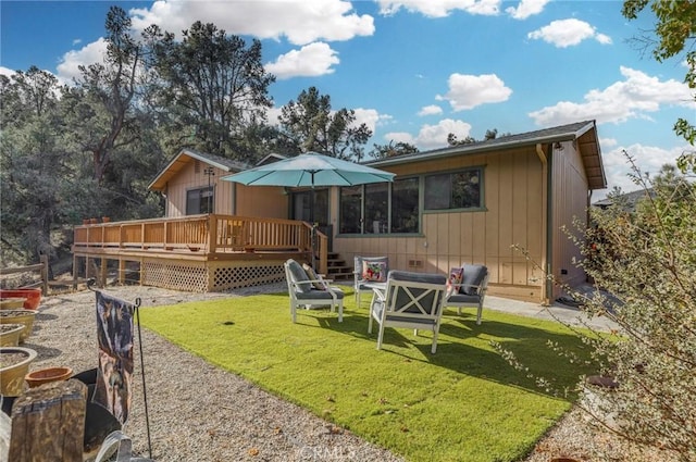 back of property with a yard and a deck