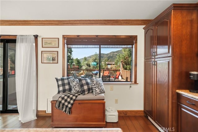 interior space with baseboards, crown molding, and hardwood / wood-style flooring