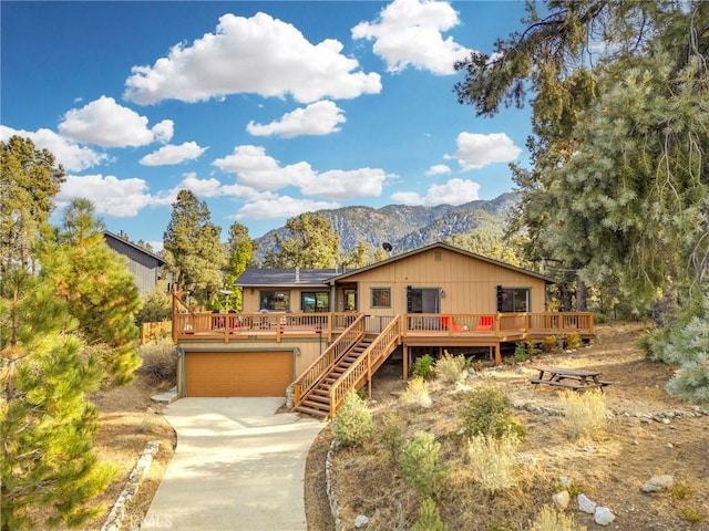 view of front facade with a deck with mountain view and solar panels