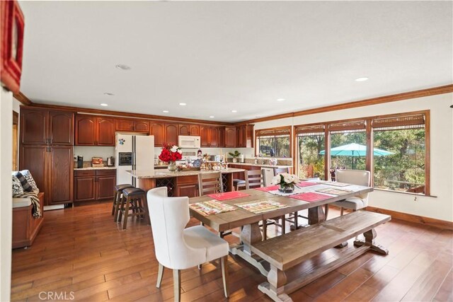 dining room with dark hardwood / wood-style flooring and crown molding