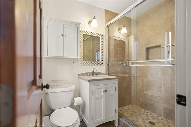 full bath with a shower stall, toilet, and vanity