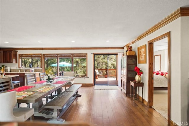 dining room with baseboards, recessed lighting, wood finished floors, and ornamental molding