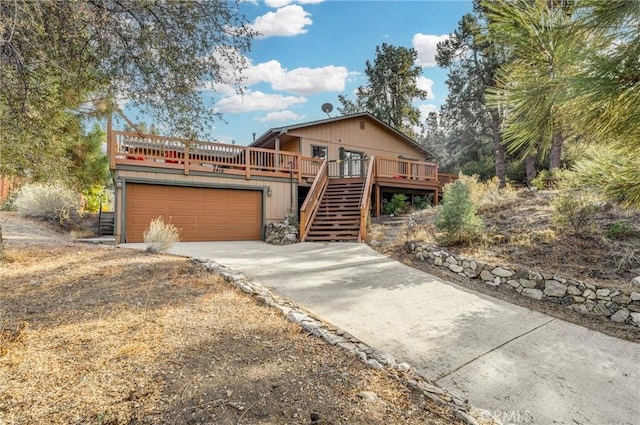 view of front facade featuring driveway, stairs, and a deck