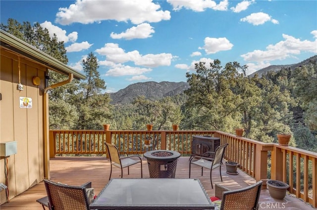 deck featuring a mountain view and an outdoor fire pit