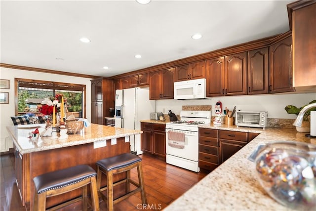 kitchen featuring light stone counters, a center island, dark wood-style floors, white appliances, and recessed lighting