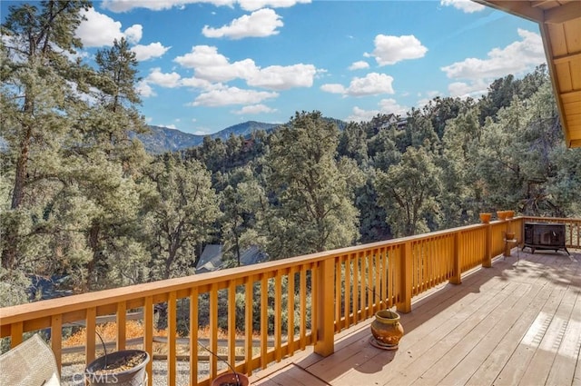 deck with a forest view and a mountain view