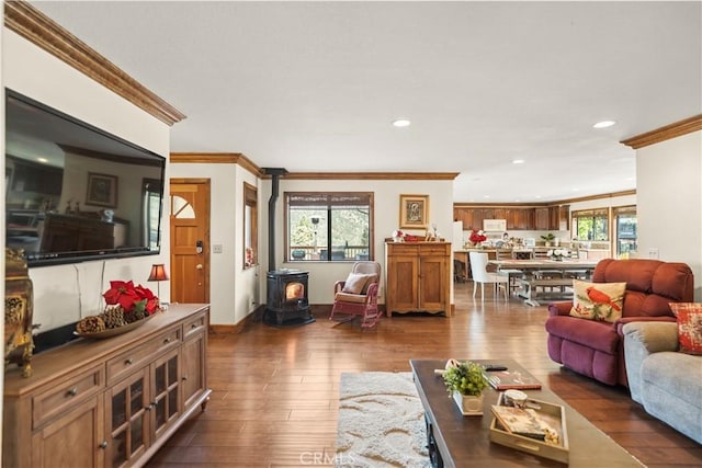 living area featuring recessed lighting, a wood stove, ornamental molding, dark wood-type flooring, and baseboards