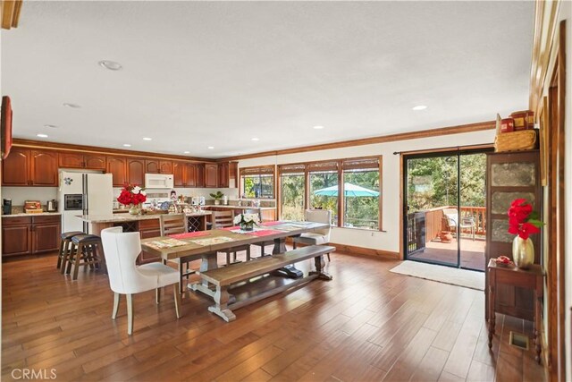 dining room featuring recessed lighting, ornamental molding, baseboards, and wood finished floors