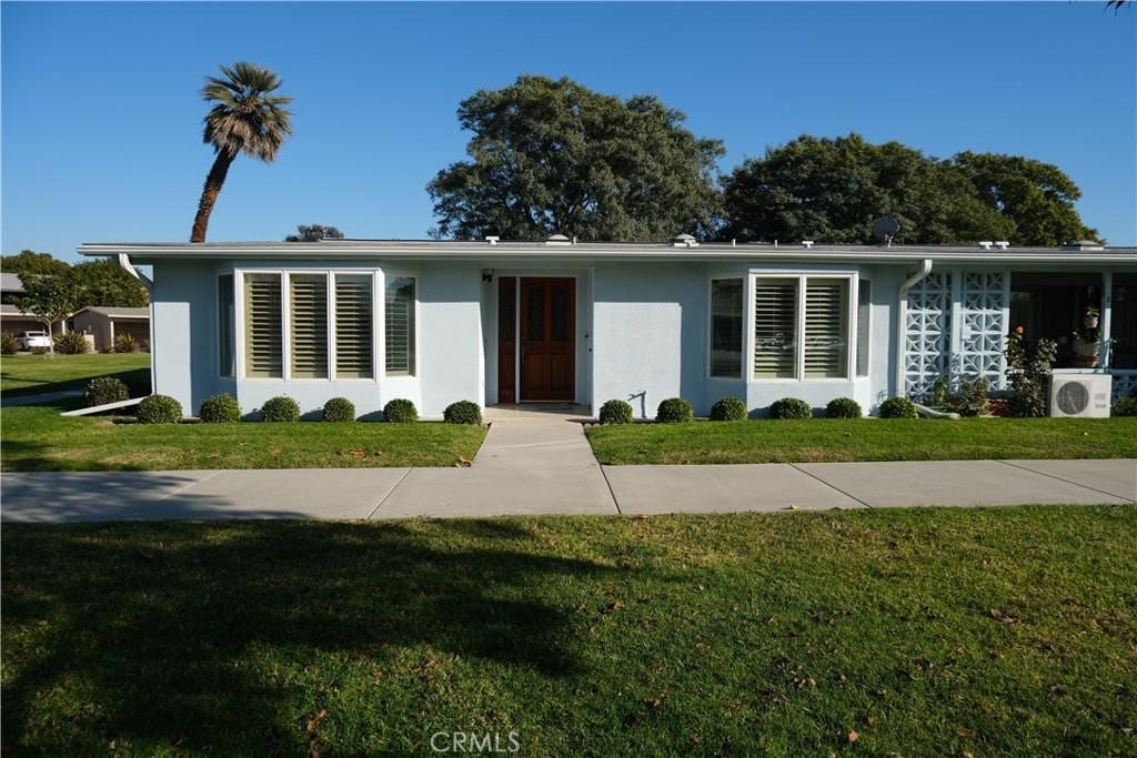 ranch-style home with ac unit and a front lawn