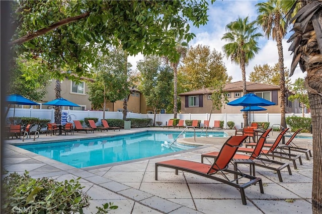 community pool with fence and a patio