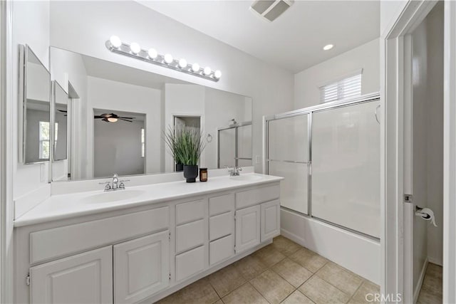 bathroom with tile patterned flooring, visible vents, bath / shower combo with glass door, and a sink