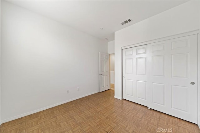 unfurnished bedroom featuring a closet, visible vents, and baseboards