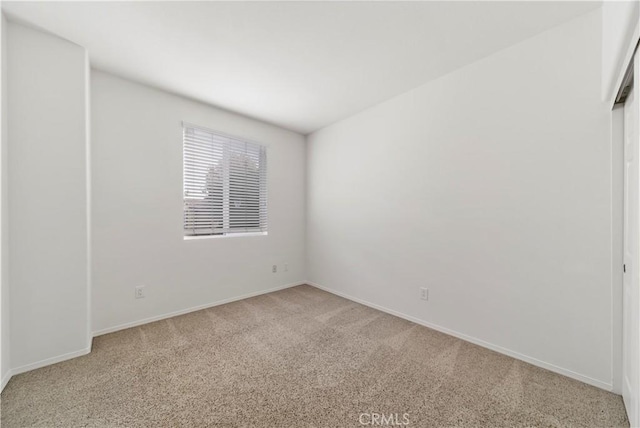 unfurnished room featuring baseboards and light colored carpet