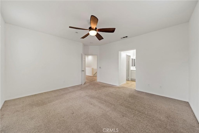 unfurnished bedroom with light carpet, baseboards, visible vents, a ceiling fan, and connected bathroom