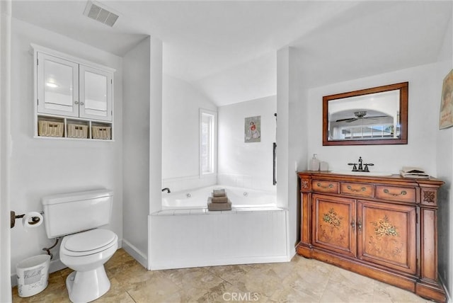 bathroom featuring a tub, tile patterned floors, lofted ceiling, toilet, and vanity