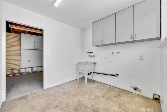 clothes washing area featuring hookup for a gas dryer and cabinets