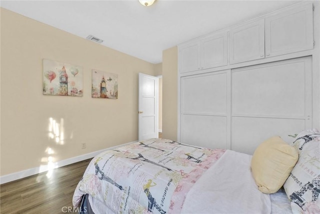 bedroom with a closet and dark wood-type flooring