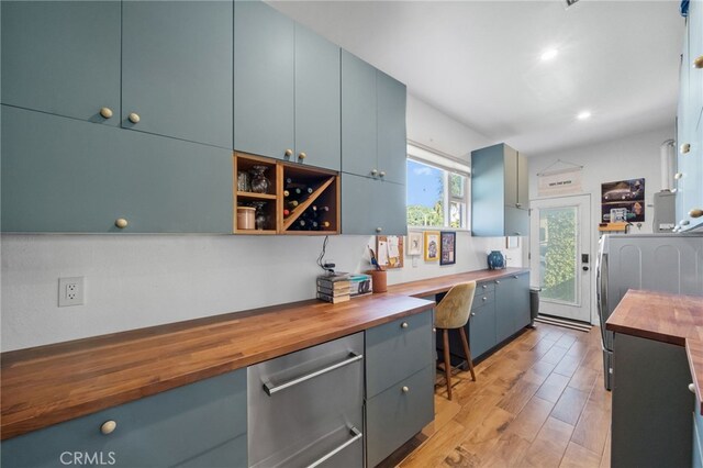 kitchen featuring wooden counters, light wood-type flooring, and built in desk