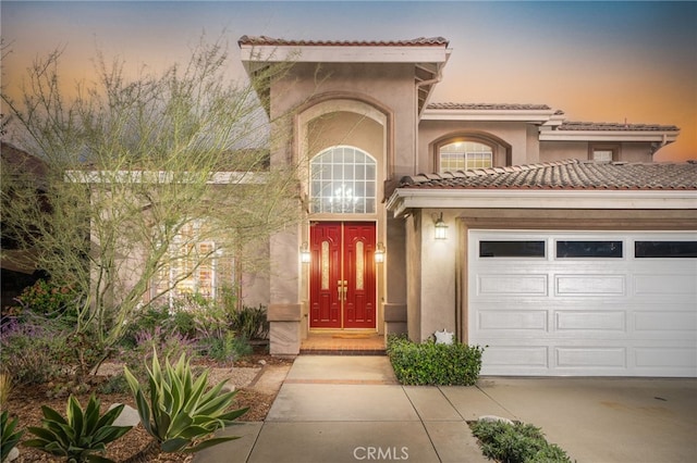 exterior entry at dusk with a garage