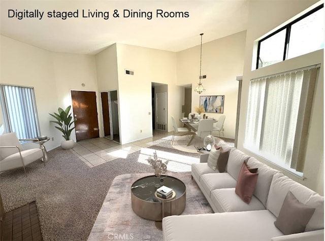 carpeted living room featuring a towering ceiling