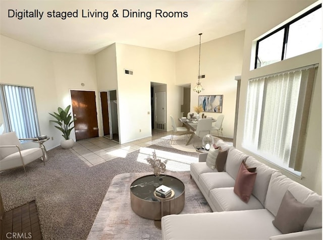 living room featuring a towering ceiling and light colored carpet