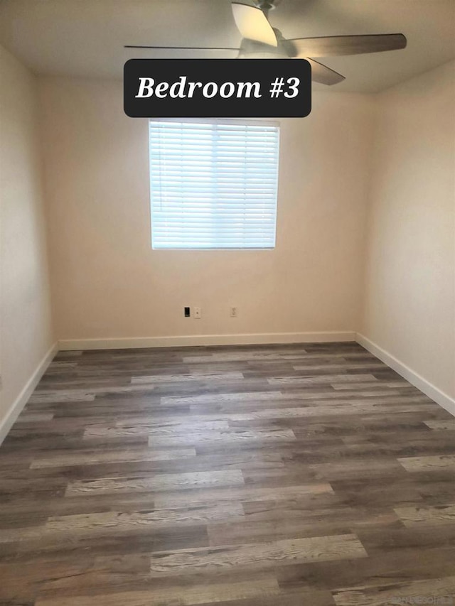 empty room featuring ceiling fan and dark hardwood / wood-style flooring