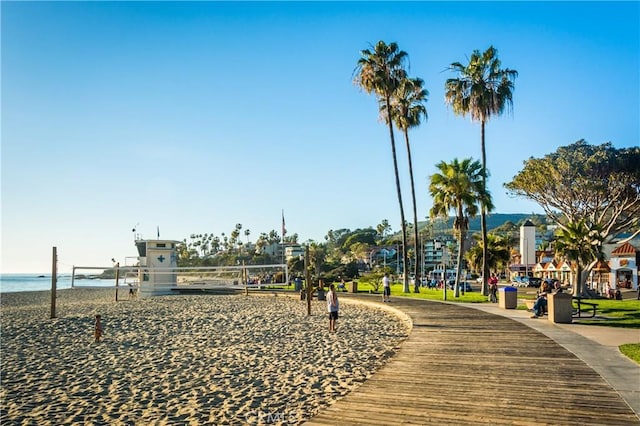 view of property's community with volleyball court and a water view