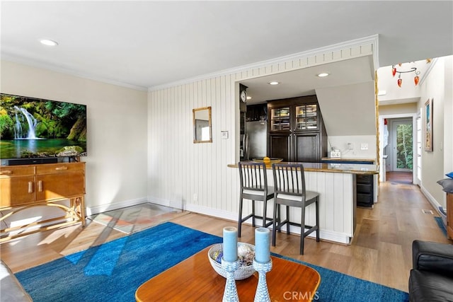 living room with wood-type flooring and ornamental molding