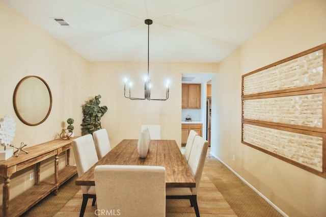 dining space with light carpet and a notable chandelier