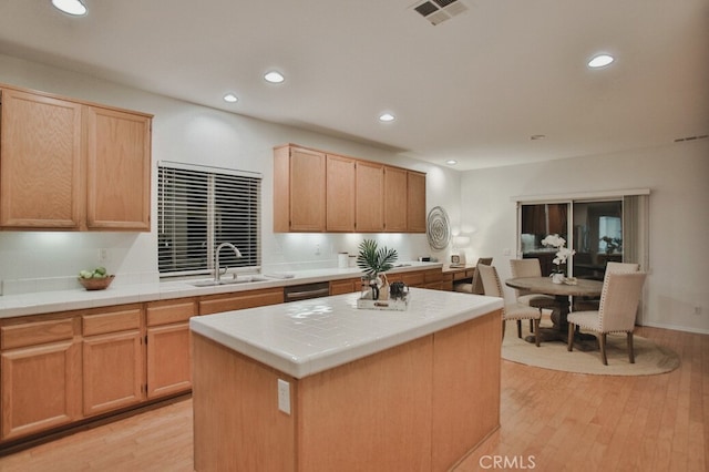 kitchen featuring tile countertops, light hardwood / wood-style floors, a center island, sink, and light brown cabinets