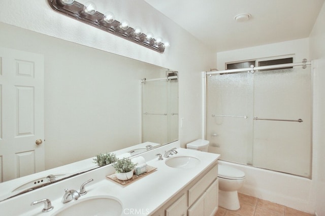 full bathroom featuring toilet, vanity, tile patterned flooring, and shower / bath combination with glass door