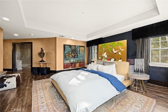 bedroom featuring a raised ceiling and hardwood / wood-style floors