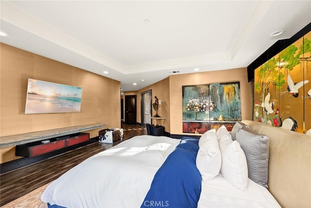 bedroom featuring dark wood-type flooring and a tray ceiling