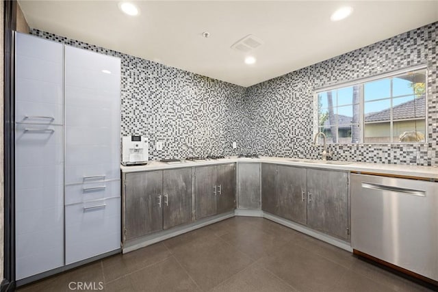 kitchen featuring dishwasher, tasteful backsplash, and sink