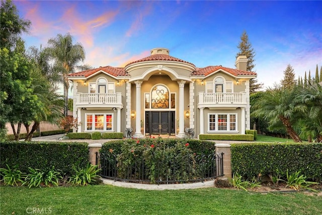 view of front of property with a yard and a balcony