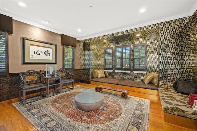 sitting room with light wood-type flooring and crown molding