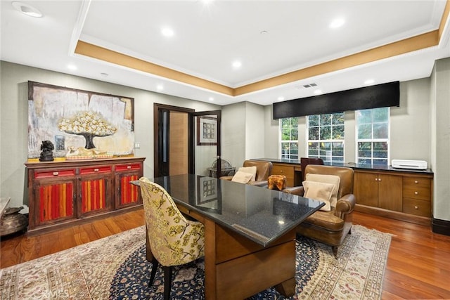 interior space featuring a tray ceiling, hardwood / wood-style floors, and ornamental molding