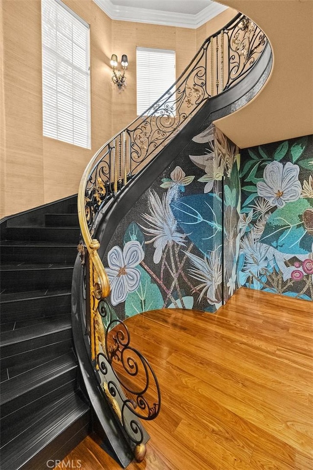 stairway with hardwood / wood-style floors and crown molding