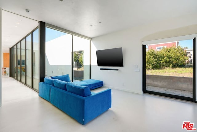 living room featuring concrete floors and a wall of windows