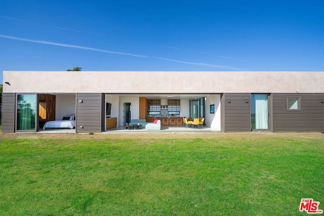 rear view of property featuring a lawn and outdoor lounge area