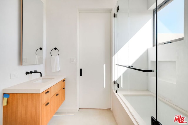 bathroom featuring vanity and shower / bath combination with glass door