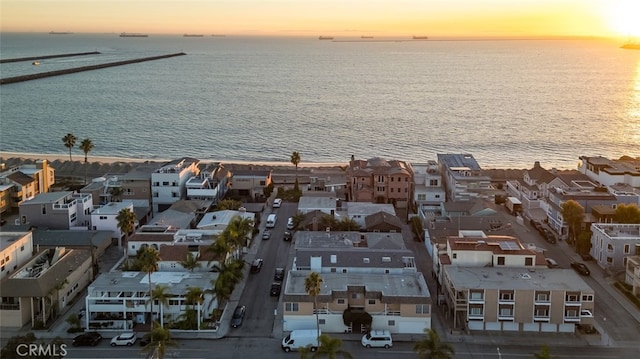 aerial view at dusk featuring a water view