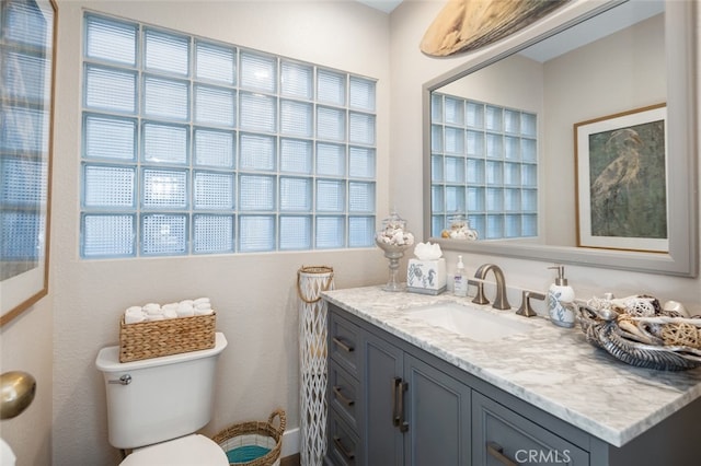 bathroom with vanity, toilet, and a wealth of natural light